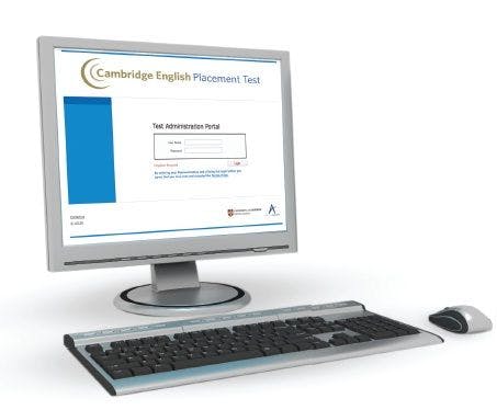 Ein Computer mit Tastatur und Maus. Der Bildschirm ist eingeschaltet und zeigt die Homepage vom Cambridge English Placement Test. 